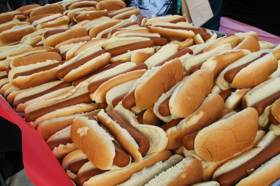 many hot dogs in buns stacked on top of each other